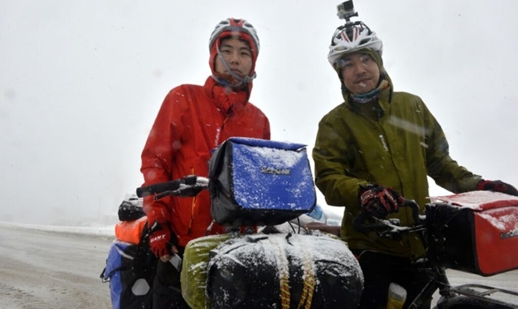 Çinli bisikletçilerin kar altında zorlu yolculuğu