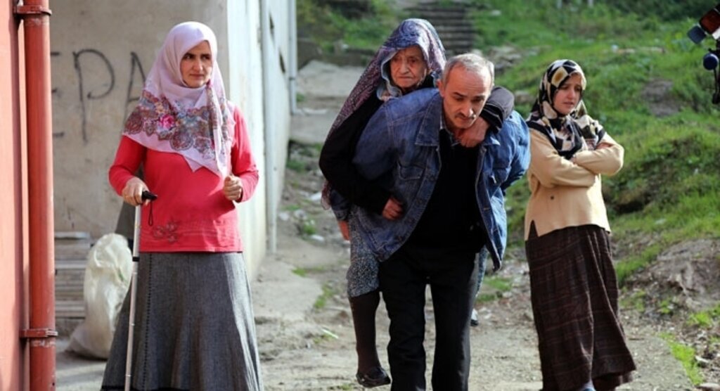 Hasta annesini araç yoluna kadar sırtında taşıyor